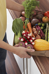 女人拿着装满新鲜蔬菜的容器中段特写