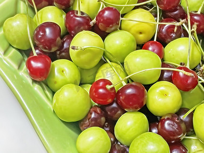 准备吃，把酸樱桃和李子洗干净，放在有水果图案的绿色盘子里