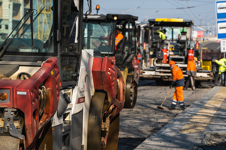 KYIV, UKRAINE - September 10, 2020：带有重型振动压路机的重型沥青压路机在街道上的道路施工现场压上新的热沥青和沥青摊铺机。