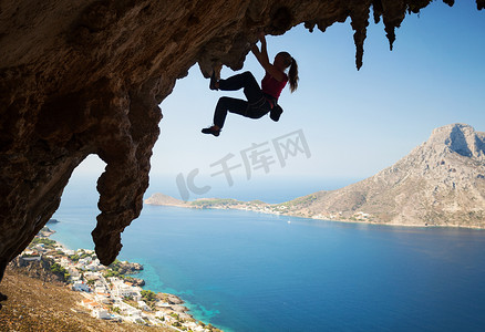 悬崖上年轻女性攀岩者的剪影