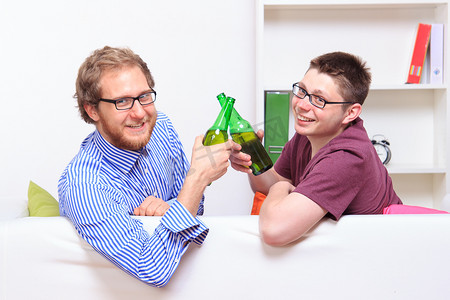 两个年轻人在沙发上喝啤酒