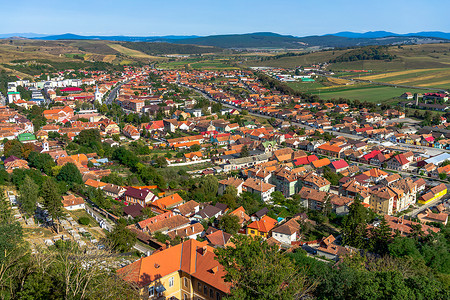 2021 年罗马尼亚 Rupea 镇中心的鸟瞰图，包括山丘、建筑物、街道、植被和周围环境