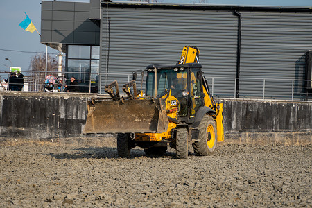 水源和土壤污染摄影照片_乌克兰，卢茨克 — 2020 年 4 月 10 日：黄色轮式装载机挖掘机在建筑工地用沙子和砾石工作。