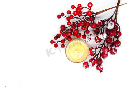 雪中​​红冬青浆果和燃烧蜡蜡烛的节日圣诞或新年组合物