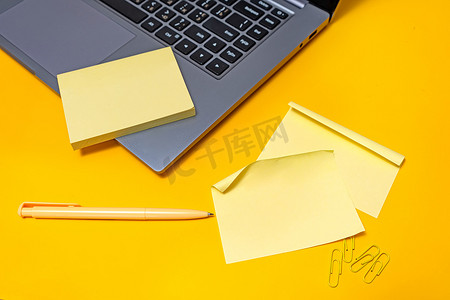 在笔记本电脑旁边写新消息更新想法的空白笔记。
