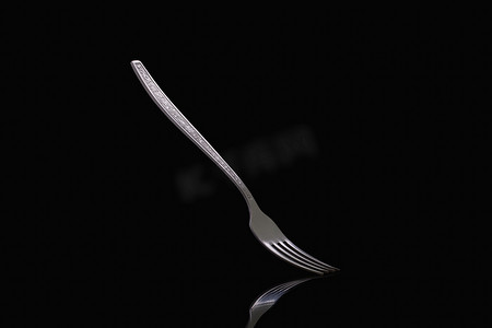 餐饮卡片摄影照片_在黑色背景上的旧钢叉。