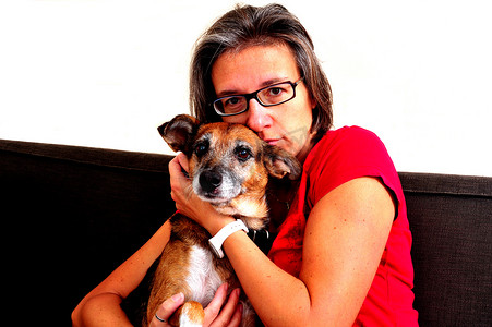 灰色沙发上抱着狗的女人