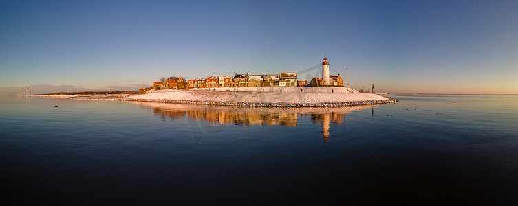 荷兰 Urk Flevoland 灯塔的全景，冬季 Urk 海滩上覆盖着白雪