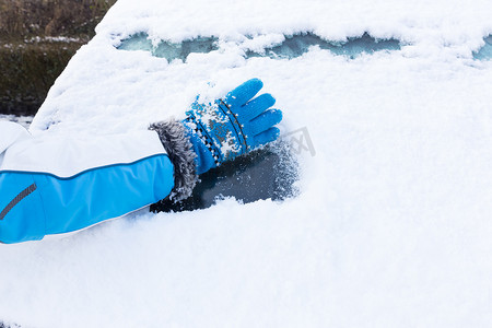 滋扰摄影照片_戴手套的手臂从车窗上除雪