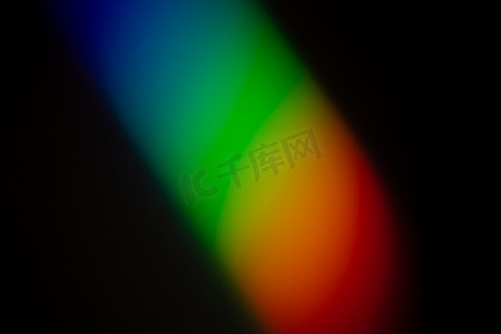 清晰而充满活力的彩虹色渐变反映在深色墙壁照片上。