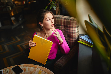 惊讶的女人在咖啡馆里看着窗外