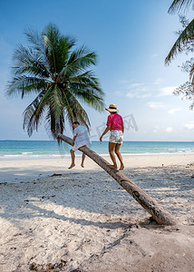 热带春摄影照片_夫妇在泰国度假，春蓬省，白色热带棕榈树海滩，Wua Laen 海滩春蓬地区泰国，棕榈树挂在海滩上，夫妇在泰国度假