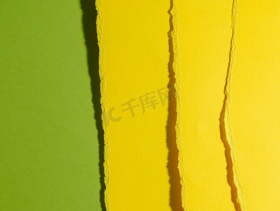 绿色背景中黄色纸板撕裂的边缘
