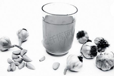 剥开的蒜瓣摄影照片_在白色隔绝的新鲜的有机大蒜汁与新鲜的蒜瓣和大蒜鳞茎一起。