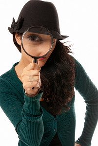 年轻女子透过放大镜放大镜侦探在白色背景下被隔离