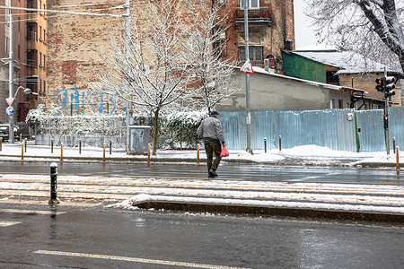 2021年罗马尼亚布加勒斯特下雪的冬日，行人穿过雪路