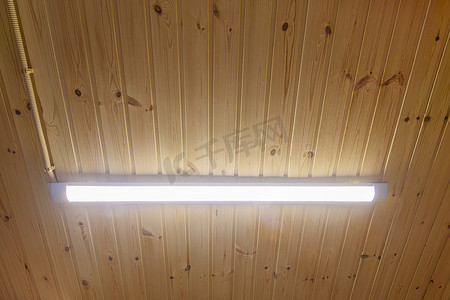 木镶板天花板上的长 LED 灯