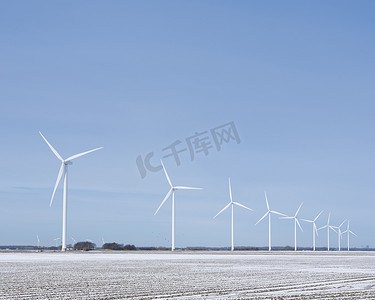 蓝天下弗莱福兰荷兰圩田积雪的田野和风力涡轮机