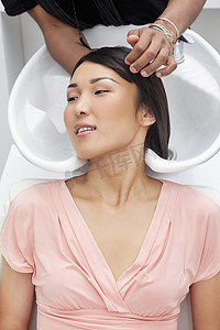 洗澡洗头摄影照片_在美容院洗头的亚洲女性