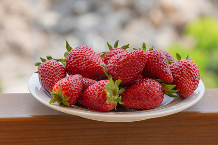 在盘子上的红色成熟草莓。