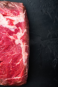 剥腰牛排，生大理石纹肉，黑色背景，顶视图
