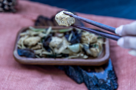 手正用筷子夹起木盘里的姜炒豆腐。
