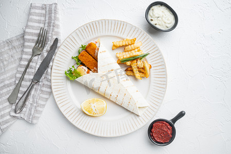 带鱼指、奶酪和蔬菜的玉米饼卷，盘子上，白色背景，顶视图平躺，有复制空间和文本空间