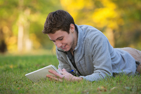 快乐的青少年在草地上写作