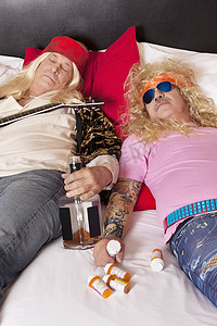 斜倚在床上的两个喝醉的男性朋友