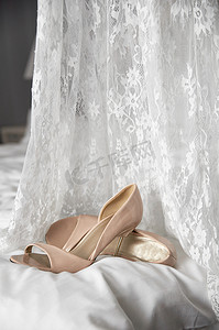 婚纱旁边床上的婚鞋