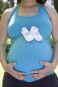 卡通短靴摄影照片_怀孕肚子上有白色短靴