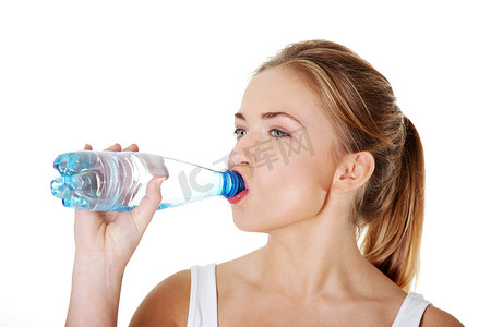 蓝色的矿泉水瓶子摄影照片_青少年从瓶子里喝矿泉水