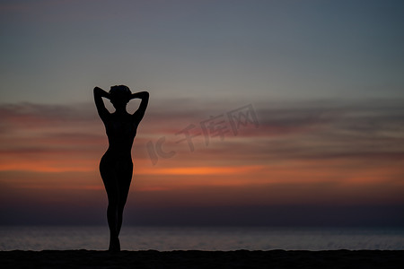 亚洲比基尼摄影照片_在海滩上穿着比基尼的女人的剪影肖像，金色的日落时刻。
