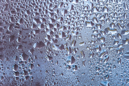 雨水花摄影照片_带有大滴水或蓝色雨的湿玻璃。