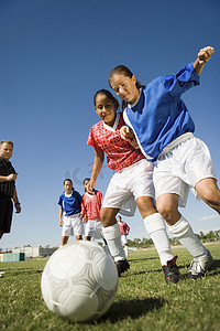女孩 (13-17) 踢足球低角度视图