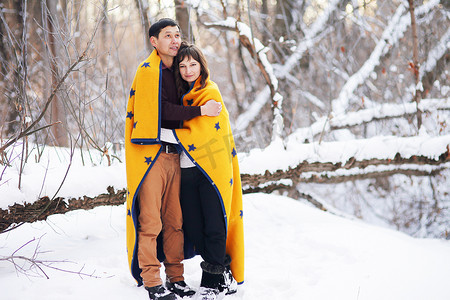 冬日恋人摄影照片_冬日，一对裹着格子呢的年轻夫妇共度时光