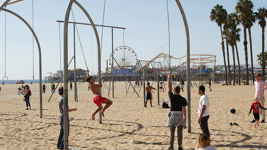 美国加利福尼亚州洛杉矶圣塔莫尼卡 — 2019 年 10 月 28 日：加州夏季太平洋海滩美学，年轻人在运动场上训练和玩乐。