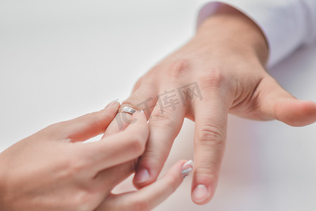 一个女人把戒指戴在她男人的无名指上。