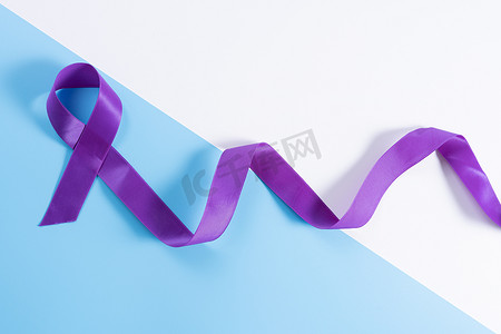 世界癌症日，紫色丝带和蓝色背景，带有文本复制空间。