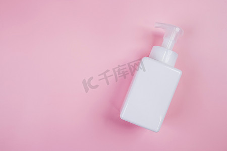 在粉红色背景上隔离的奶油或乳液样机化妆品瓶，用于广告、护肤或美容的样机包装、顶视图、平躺、皮肤护理和产品治疗。