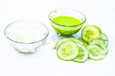 在白色上隔离的黄瓜面膜，即黄瓜果肉与 dahi 或酸奶在玻璃碗中充分混合，所有原料都存在于表面。用于治疗易长粉刺的皮肤。