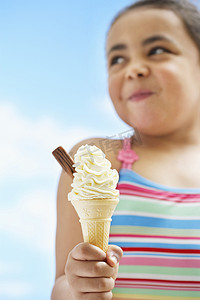 拿着冰淇淋的女孩（7-9 岁）专注于冰淇淋