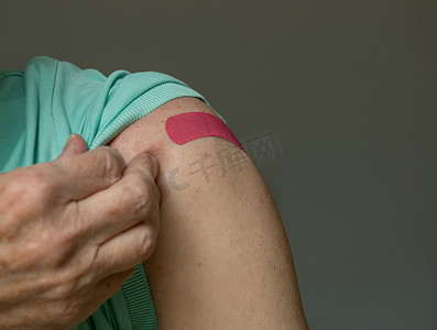 注射 covid-19 疫苗后举起衬衫的老人