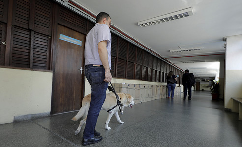给盲人指路摄影照片_盲人在萨尔瓦多使用导盲犬移动