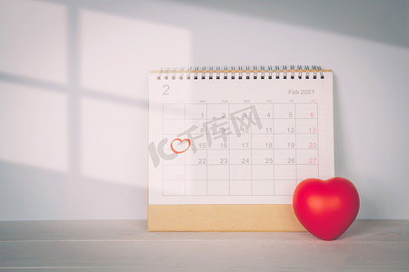 日历和心形与备忘录 2 月 14 日情人节在办公桌上，提醒爱情惊喜、浪漫和甜蜜、庆祝和装饰、约会和计划者、无人、顶视图、假日概念。