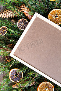 圣诞背景与干橙片和绿色多刺冷杉树枝上的空框板。