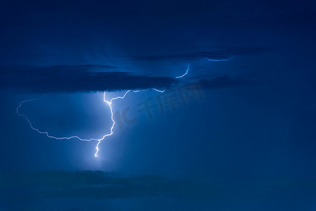 雷阵雨摄影照片_雷暴雷击在夜间乌云密布的天空背景上。