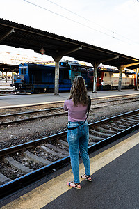 少女独自走在火车站台上，在火车站拍照