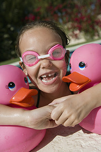 泳池边拿着粉红色橡皮鸭的女孩