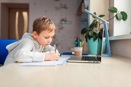 可爱的小男生在家学习做学校作业。